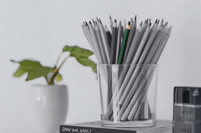 Un pot à crayons avec un crayon vert pour symboliser la meilleure manière de répondre aux critères RSE des clients de PME.